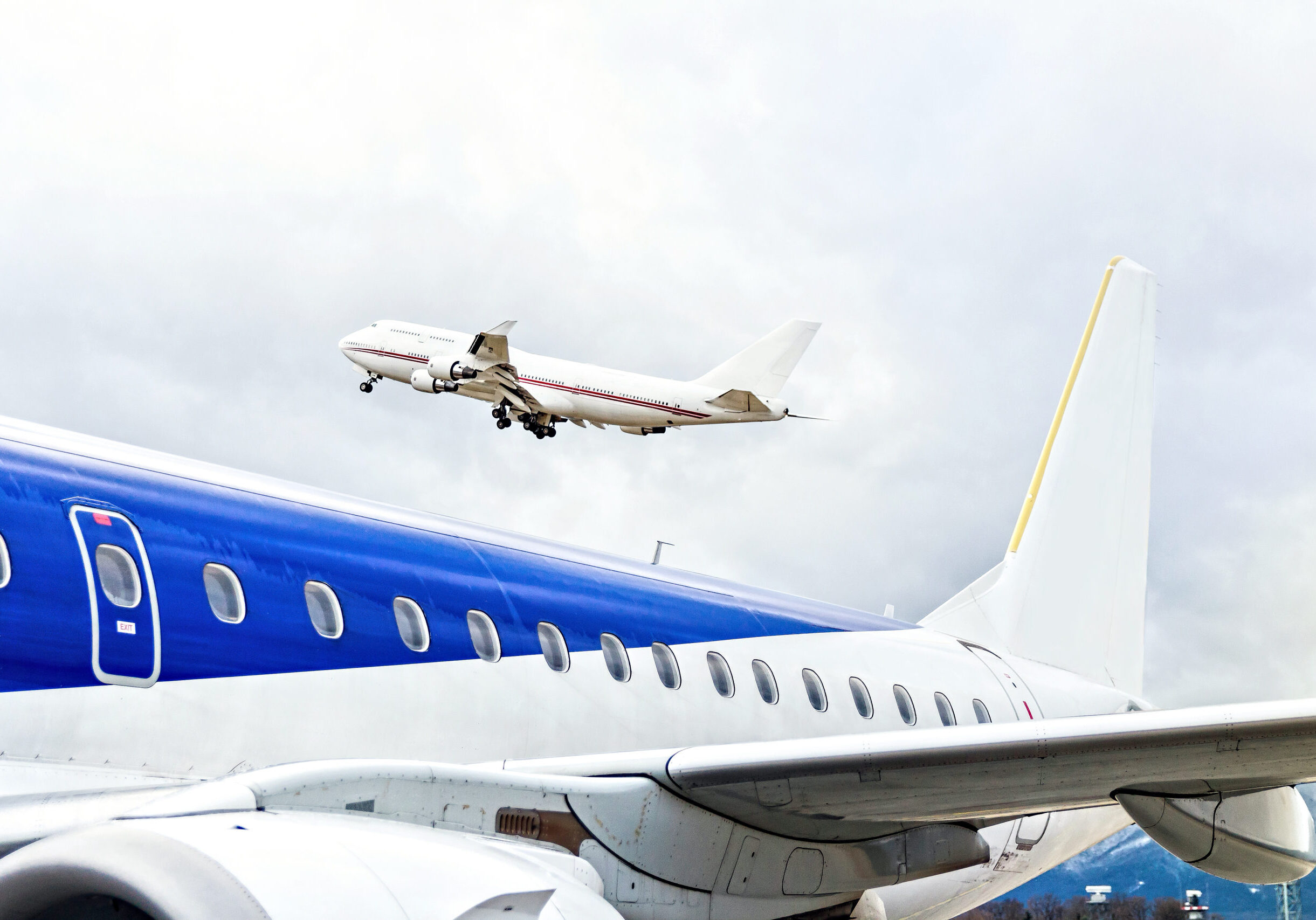 Taking off aircraft at the airport in cold weather, big blue plane wings close up, diagonal lines